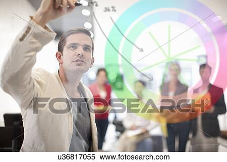 Man writing on glass screen, colleagues watching View Large Photo Image Stock Photography - Man writing on glass screen, colleagues watching. Fotosearch