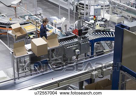 Picture - Mature woman working in paper packaging factory. Fotosearch