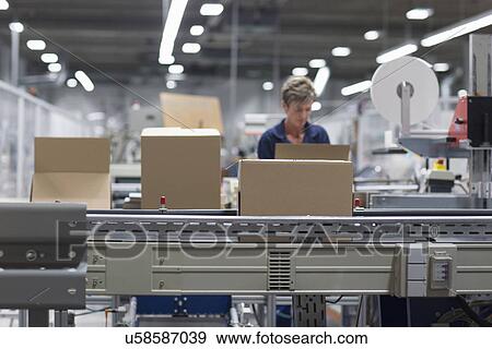 Stock Photo - Mature woman working in paper packaging factory. Fotosearch