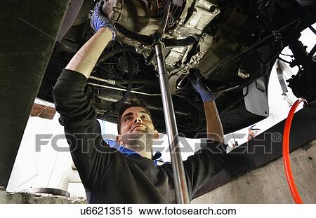 Mechanic checking car undercarriage View Large Photo Image Stock Photography - Mechanic checking car undercarriage. Fotosearch