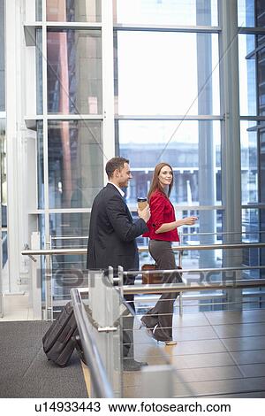 Mid adult businesswoman and colleague on conference centre walkway View Large Photo Image Stock Image - Mid adult businesswoman and colleague on conference centre walkway. Fotosearch