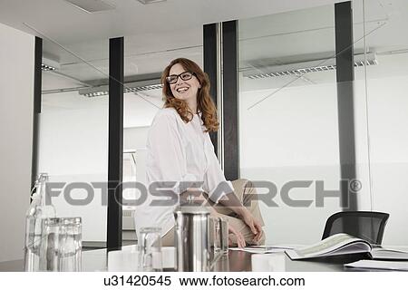 Mid adult businesswoman sitting in conference room View Large Photo Image Stock Photography - Mid adult businesswoman sitting in conference room. Fotosearch