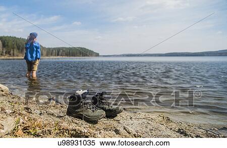 Stock Photography - Mid adult female hiker taking a paddle in lake. Fotosearch