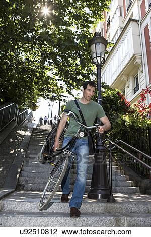 Mid adult male carrying bicycle down stairway in Paris, France View Large Photo Image Stock Image - Mid adult male carrying bicycle down stairway in Paris, France. Fotosearch