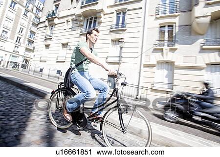 Mid adult male cyclist speeding down cobbled street, Paris, France View Large Photo Image Stock Image - Mid adult male cyclist speeding down cobbled street, Paris, France. Fotosearch