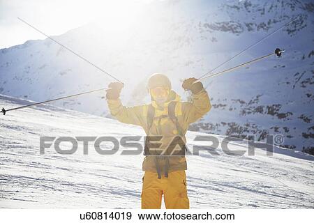 Mid adult male skier holding up ski poles in celebration, Austria View Large Photo Image Stock Photo - Mid adult male skier holding up ski poles in celebration, Austria. Fotosearch