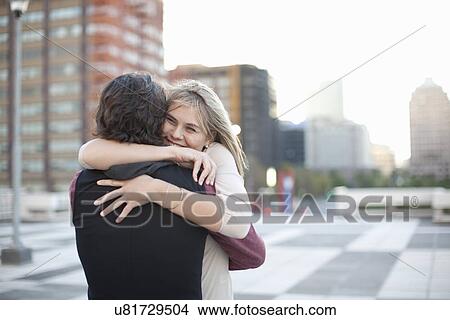 Mid adult man hugging girlfriend on rooftop parking lot View Large Photo Image Picture - Mid adult man hugging girlfriend on rooftop parking lot. Fotosearch