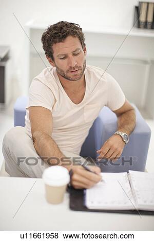 Mid adult man making notes View Large Photo Image Stock Photo - Mid adult man making notes. Fotosearch