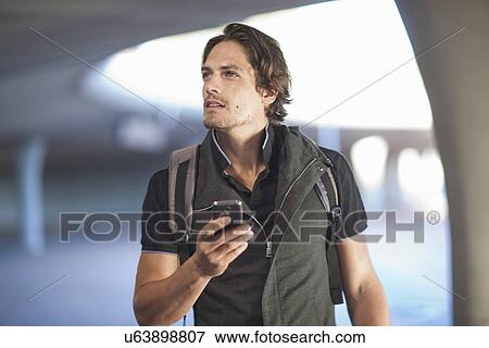 Mid adult man navigating with smartphone in city View Large Photo Image Stock Photo - Mid adult man navigating with smartphone in city. Fotosearch