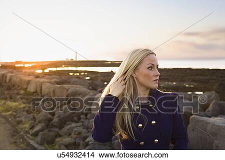 Picture - Mid adult woman gazing from waterfront, Seltjarnarnes, Iceland. Fotosearch