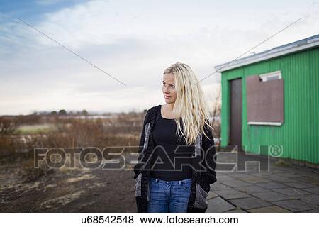 Mid adult woman waiting outside hut View Large Photo Image Stock Photo - Mid adult woman waiting outside hut. Fotosearch