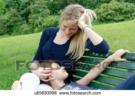 Mother and daughter relaxing on park bench View Large Photo Image Stock Photo - Mother and daughter relaxing on park bench. Fotosearch