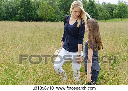 Mother and daughter strolling through grassy field View Large Photo Image Stock Image - Mother and daughter strolling through grassy field. Fotosearch