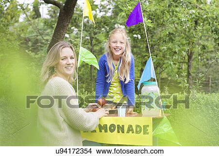Picture - Mother buying lemonade from daughter's stand. Fotosearch