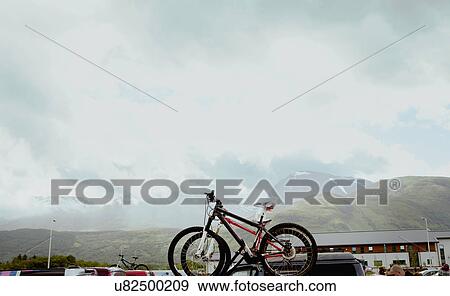 Stock Photo - Mountain bikes on roof rack in parking lot, Scottish Highlands, Scotland. Fotosearch
