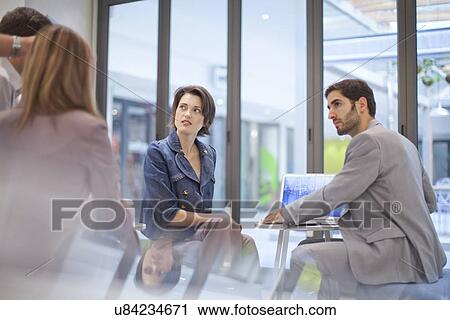 Stock Image - Office colleagues having discussion. Fotosearch