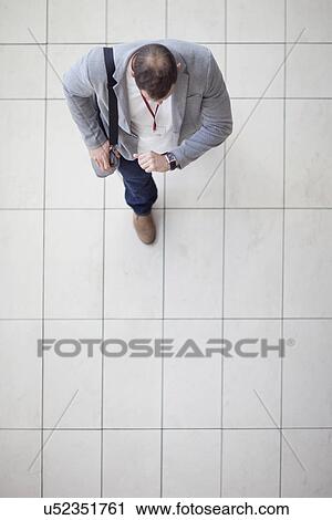 Overhead view of businessman walking through conference centre atrium View Large Photo Image Stock Image - Overhead view of businessman walking through conference centre atrium. Fotosearch