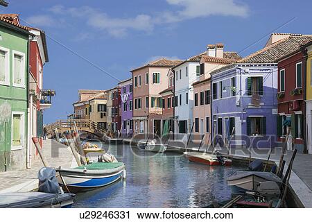 Stock Image - Pastel colored houses and boats on canal, Burano, Venice, Veneto, Italy. Fotosearch