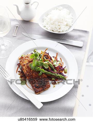 Stock Photo - Plate of salmon lemongrass and asparagus with bowl of steamed rice. Fotosearch