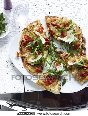 Plate of sliced wholemeal pizza with herbs, vegetable and parmesan View Large Photo Image Stock Photo - Plate of sliced wholemeal pizza with herbs, vegetable and parmesan. Fotosearch