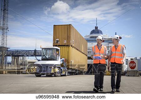 Port workers and truck unloading shipping containers from ship to port View Large Photo Image Stock Photo - Port workers and truck unloading shipping containers from ship to port. Fotosearch