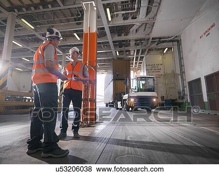 Port workers loading containers into ship's hold View Large Photo Image Stock Photo - Port workers loading containers into ship's hold. Fotosearch