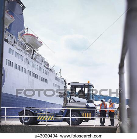 Port workers with shipping container truck and ship in port View Large Photo Image Picture - Port workers with shipping container truck and ship in port. Fotosearch