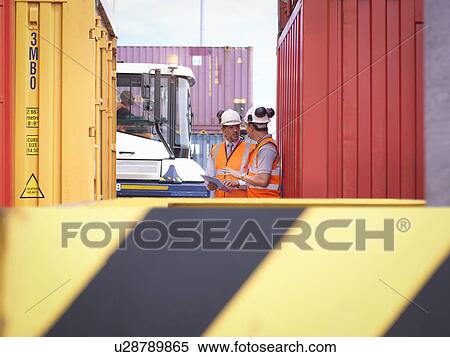 Stock Photography - Port workers with shipping containers in port. Fotosearch