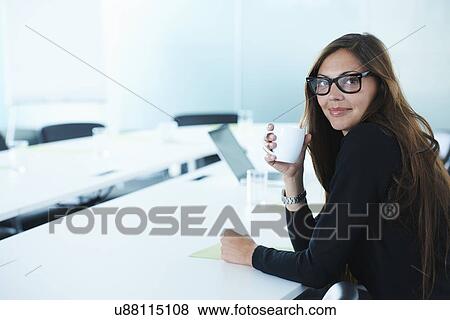 Portrait of businesswoman drinking coffee at conference table View Large Photo Image Stock Photo - Portrait of businesswoman drinking coffee at conference table. Fotosearch