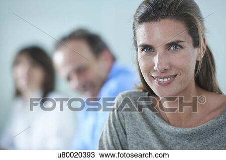 Stock Image - Portrait of businesswoman in row of colleagues. Fotosearch