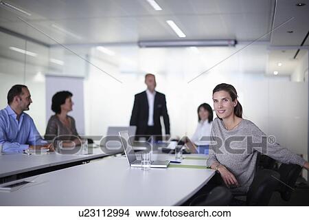 Portrait of businesswoman with colleagues at boardroom table View Large Photo Image Picture - Portrait of businesswoman with colleagues at boardroom table. Fotosearch