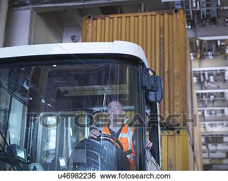 Stock Photograph - Portrait of container truck driver in ship's hold. Fotosearch