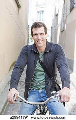 Portrait of mid adult man on bicycle in city street View Large Photo Image Stock Image - Portrait of mid adult man on bicycle in city street. Fotosearch