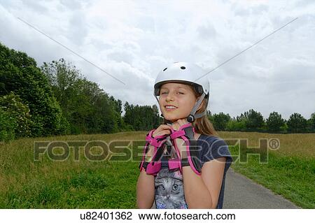 Portrait of rollerblading girl fastening skate helmet View Large Photo Image Stock Image - Portrait of rollerblading girl fastening skate helmet. Fotosearch