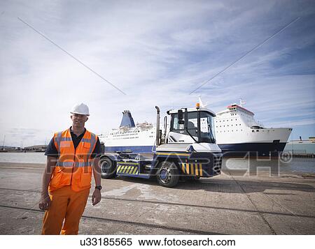 Stock Photography - Portrait of shipping container truck driver and ship in port. Fotosearch