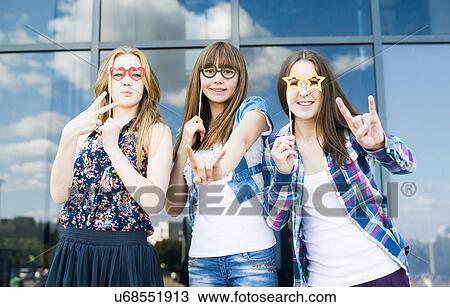 Portrait of three young women with eyeglasses costume masks and making hand gestures View Large Photo Image Stock Image - Portrait of three young women with eyeglasses costume masks and making hand gestures. Fotosearch