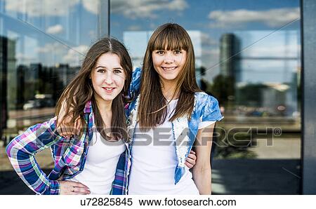 Portrait of two smiling young women in front of glass fronted office building View Large Photo Image Stock Photography - Portrait of two smiling young women in front of glass fronted office building. Fotosearch