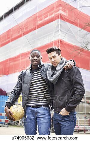 Portrait of two young men on street holding soccer ball View Large Photo Image Stock Image - Portrait of two young men on street holding soccer ball. Fotosearch