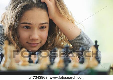 Portrait of young girl playing chess View Large Photo Image Stock Photo - Portrait of young girl playing chess. Fotosearch