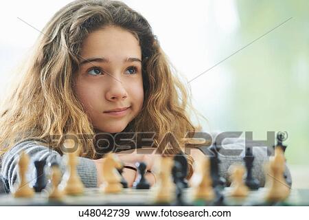 Stock Photo - Portrait of young girl playing chess. Fotosearch