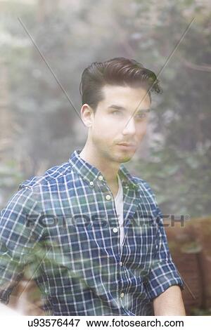 Stock Photo - Portrait of young man behind window. Fotosearch