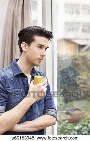 Portrait of young man gazing through patio door View Large Photo Image Stock Photo - Portrait of young man gazing through patio door. Fotosearch