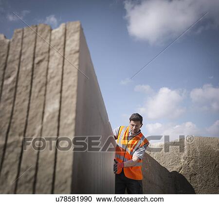 Quarry worker inspecting cut stone, low angle view View Large Photo Image Stock Image - Quarry worker inspecting cut stone, low angle view. Fotosearch