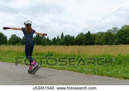 Rear view of girl rollerblading in park View Large Photo Image Stock Image - Rear view of girl rollerblading in park. Fotosearch