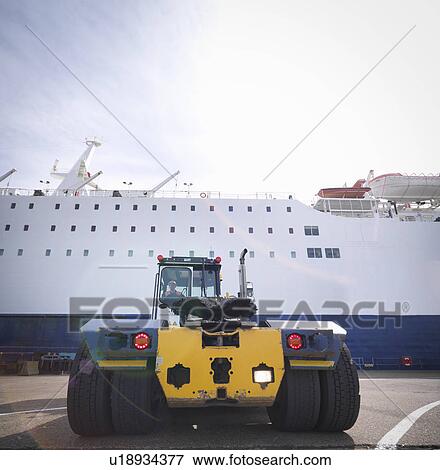 Stock Photo - Shipping container truck and driver with ship in port. Fotosearch