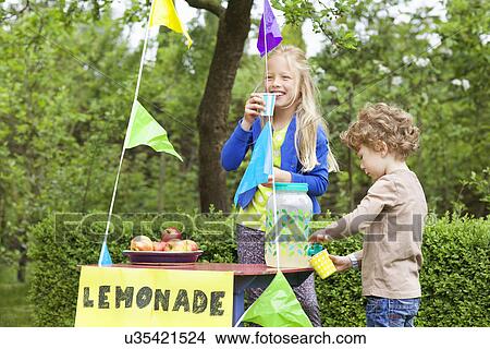 Picture - Siblings at their lemonade stand in their garden. Fotosearch
