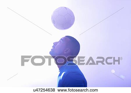 Studio shot of young male soccer player keeping ball mid air with header View Large Photo Image Stock Photo - Studio shot of young male soccer player keeping ball mid air with header. Fotosearch