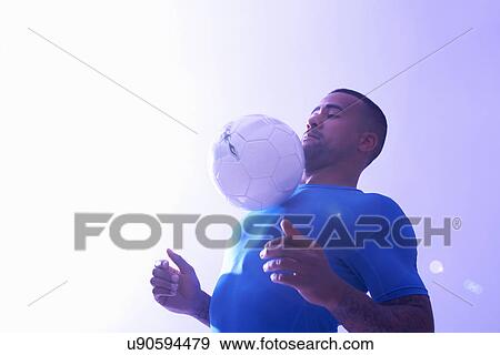 Studio shot of young male soccer player keeping ball mid air with chest View Large Photo Image Stock Photo - Studio shot of young male soccer player keeping ball mid air with chest. Fotosearch