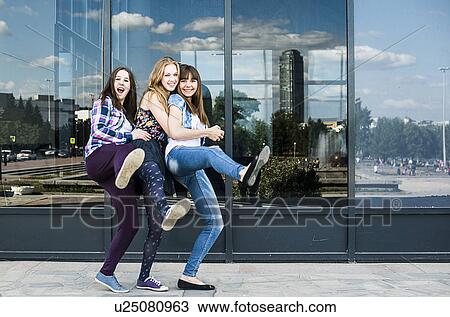 Three young women dancing on one leg in city View Large Photo Image Stock Image - Three young women dancing on one leg in city. Fotosearch