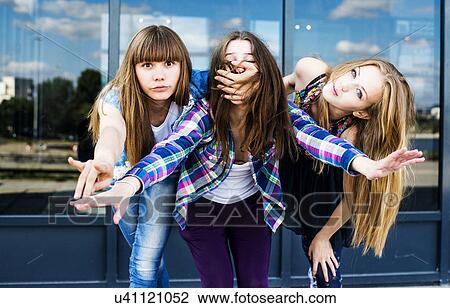 Three young women in a row leaning forward and covering mouth View Large Photo Image Stock Image - Three young women in a row leaning forward and covering mouth. Fotosearch